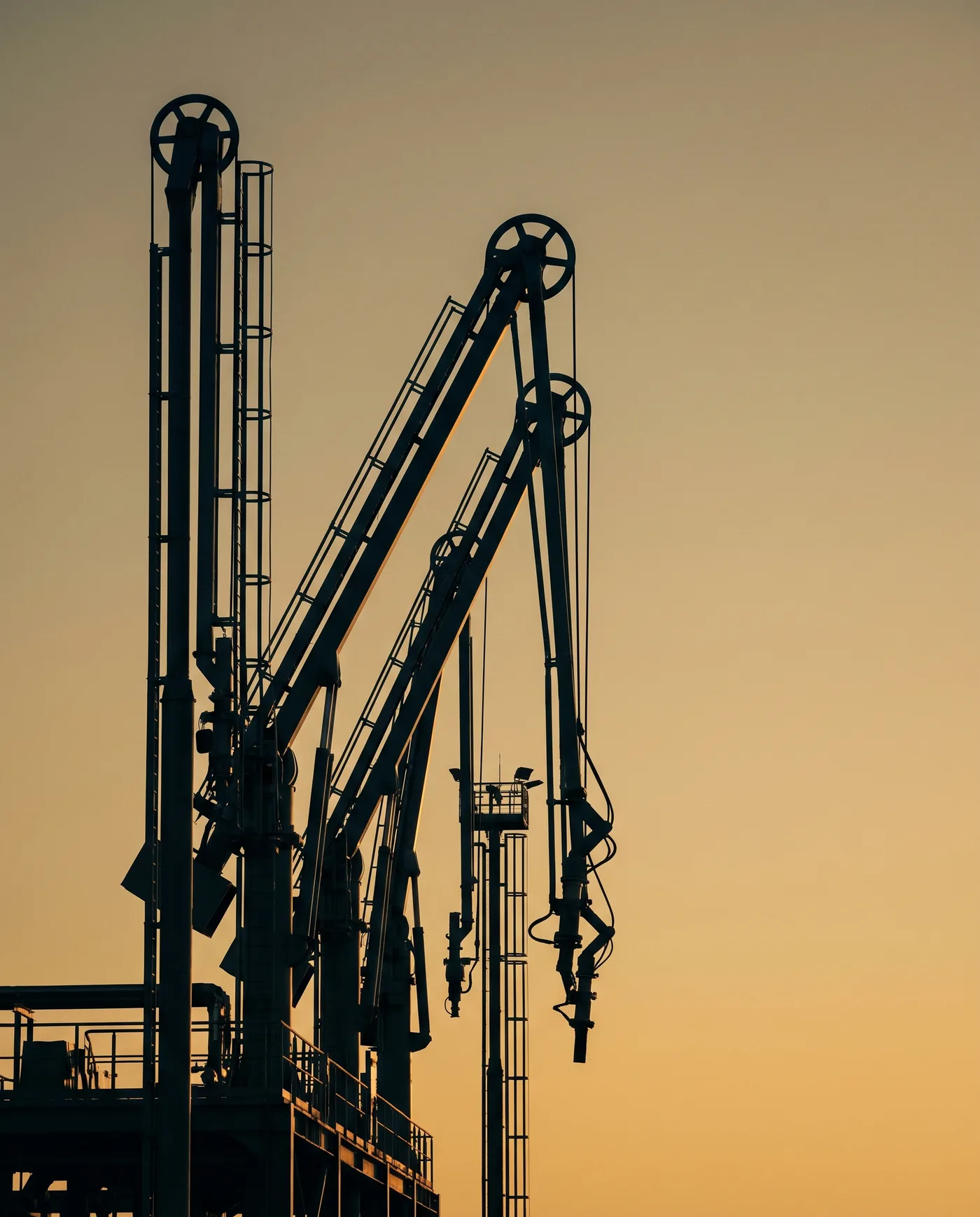 Loading arms silhouetted against evening light.