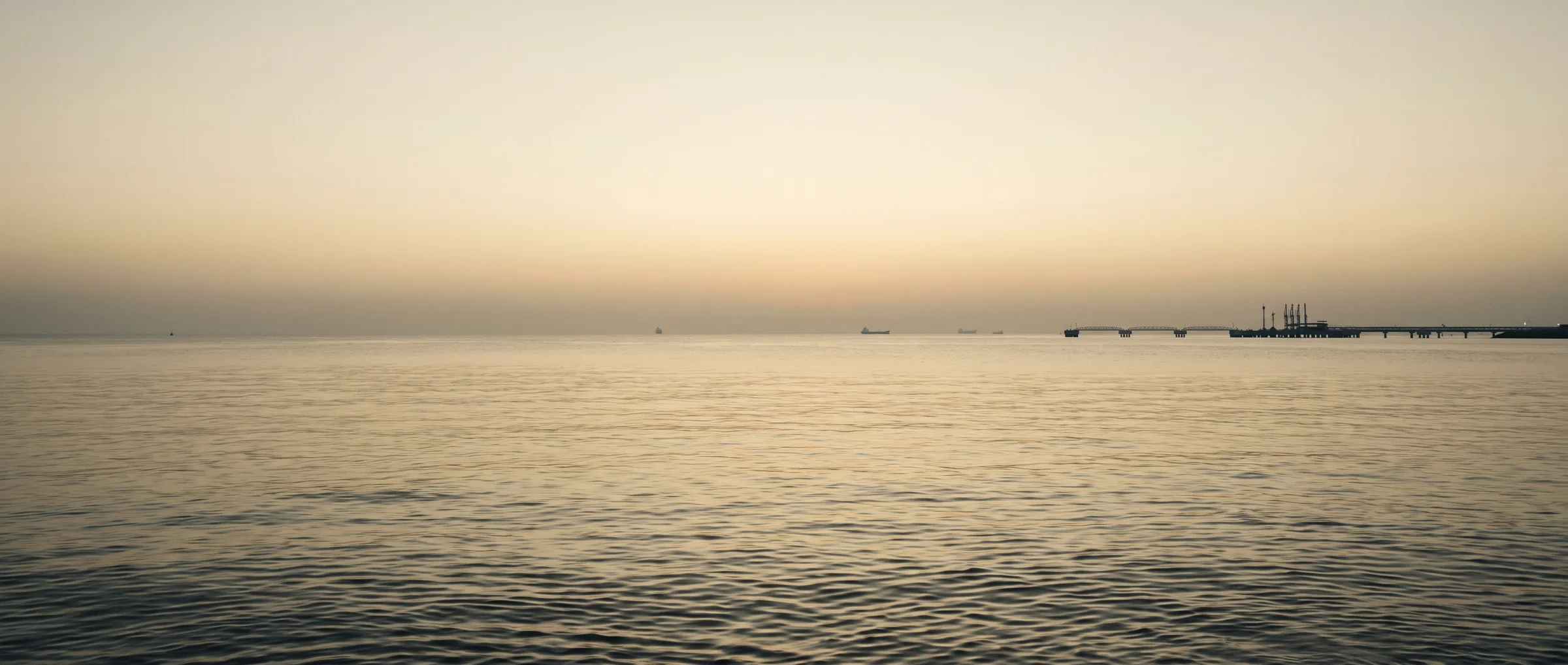 Vessels at anchorage in calm water at first light.